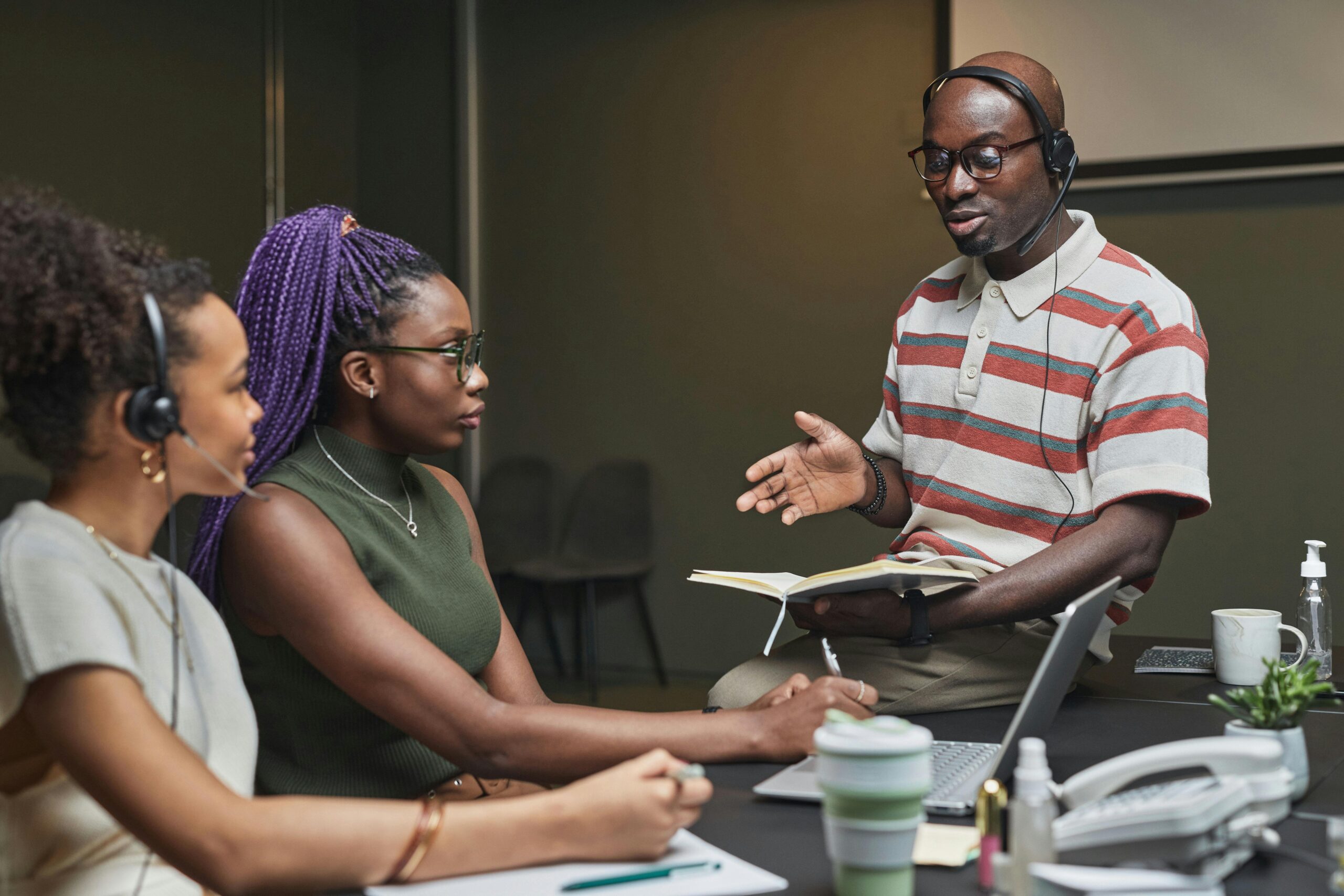 Professional discussion among colleagues in a modern office environment with technology and books.
